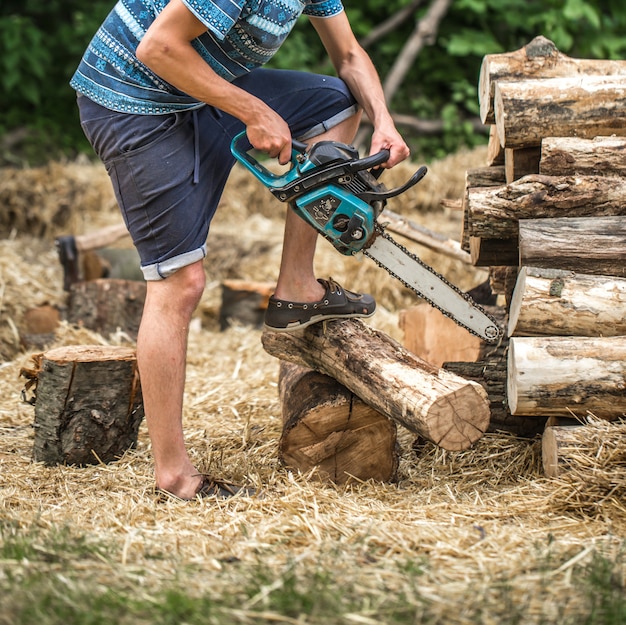 Man hakken hout met een kettingzaag