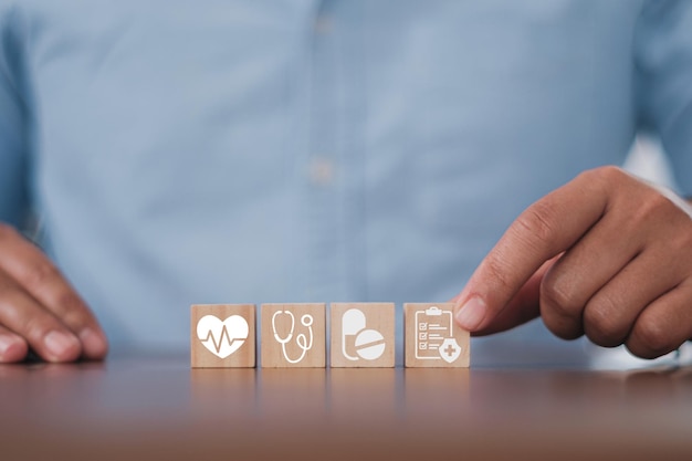 Photo man hand arranging wood block stacking with the healthcare medical icon. health insurance - health concept