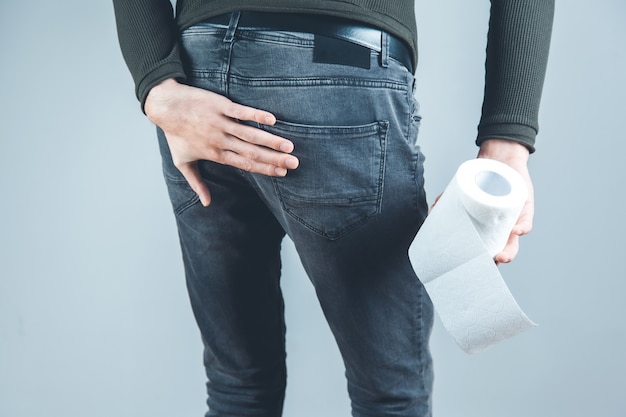 Man hand on the ass with toilet paper