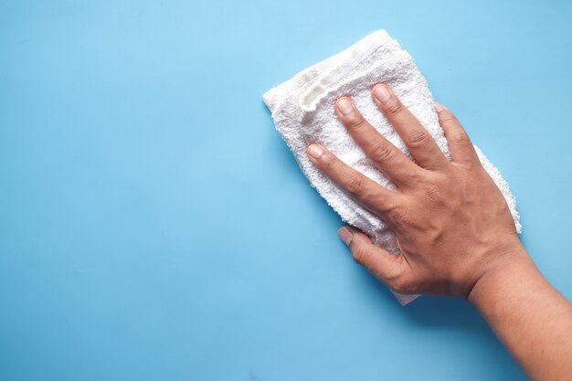 Man hand cleaning flat surface with cloth