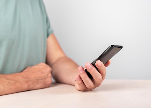 Man hand close-up met telefoon Man met smartphone voor het lezen van nieuwsboek kijken naar video Digitale technologieën in het moderne leven