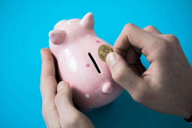 Man hand coin with piggy bank