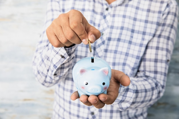 Man hand coin with piggy bank