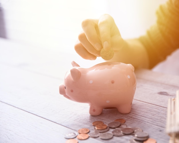 Man hand coins with piggy bank