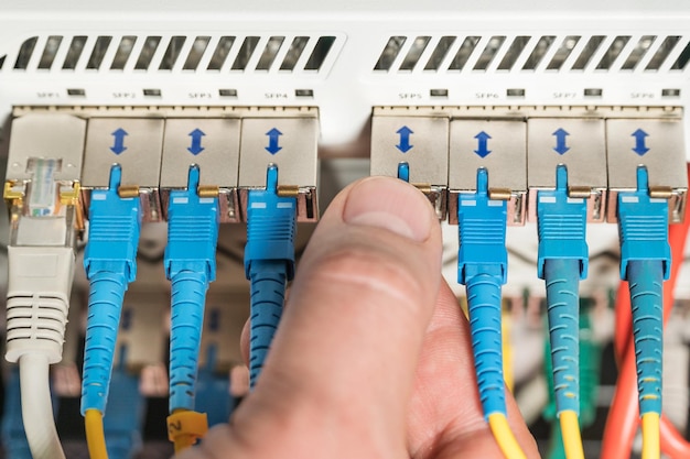 Foto la mano dell'uomo collega il filo al router, primo piano