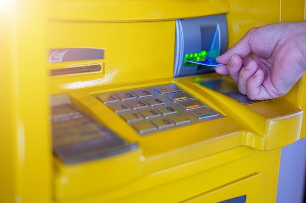 Man hand die een creditcard opneemt in ATM