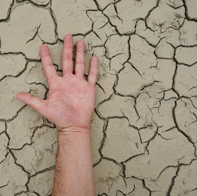 man hand on the dry ground, global warming