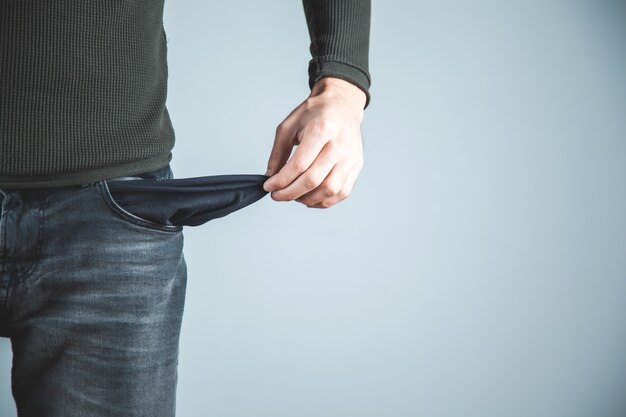 Man  hand on empty pocket on gray background