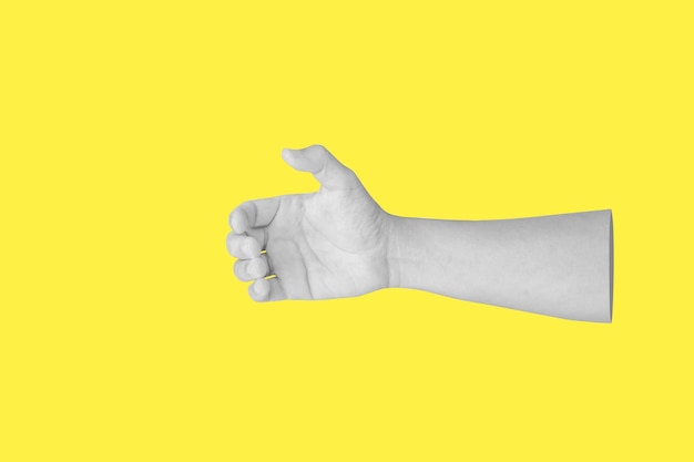 Foto gesto della mano dell'uomo che tiene qualcosa di simile a una bottiglia isolata su sfondo giallo