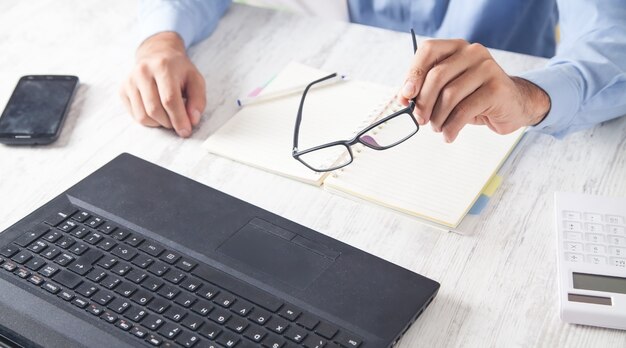 Man hand glasses working in office.