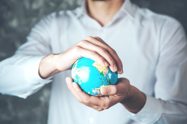 Photo man hand globe on dark background