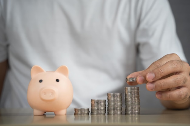 Man hand holding coins and piggy bank on table saving money wealth and financial concept Business finance investment Financial planning Business financial saving for future concept