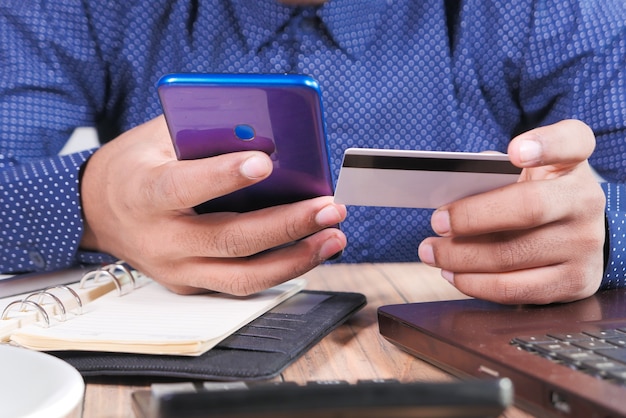 Человек рука кредитной карты и использование смарт-телефона покупки в Интернете