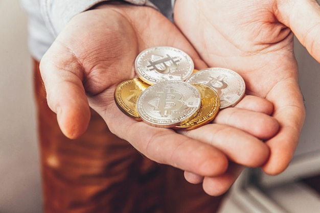 남자 손을 잡고 cryptocurrency 황금과 은색 bitcoin 동전