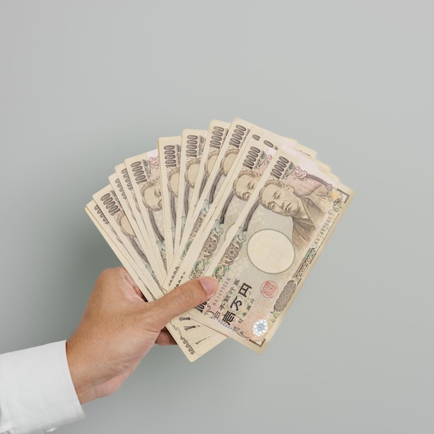 Man hand holding Japanese Yen banknote stack Thousand Yen money Japan cash Tax Recession Economy Inflation Investment finance and shopping payment concepts