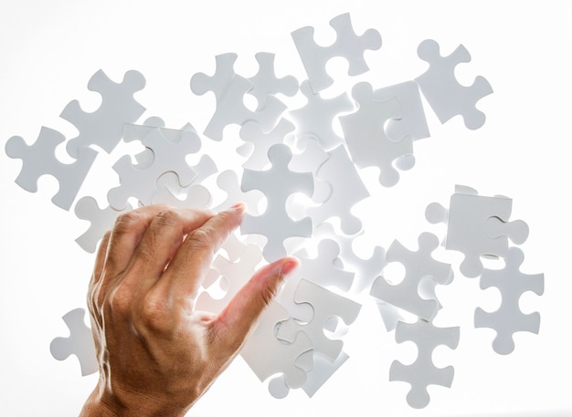 Man hand holding jigsaw puzzle piece