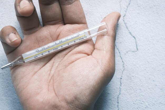 Man hand holding medical thermometer