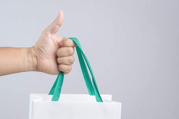 A man hand holding shopping bag with thumb up gesture
