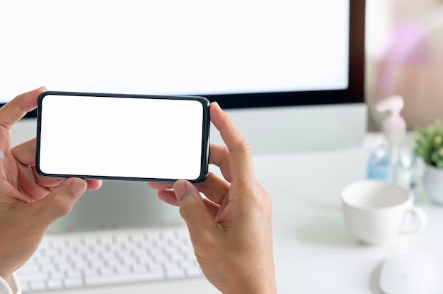 Man hand holding smartphone with blank screen in horizontal view.