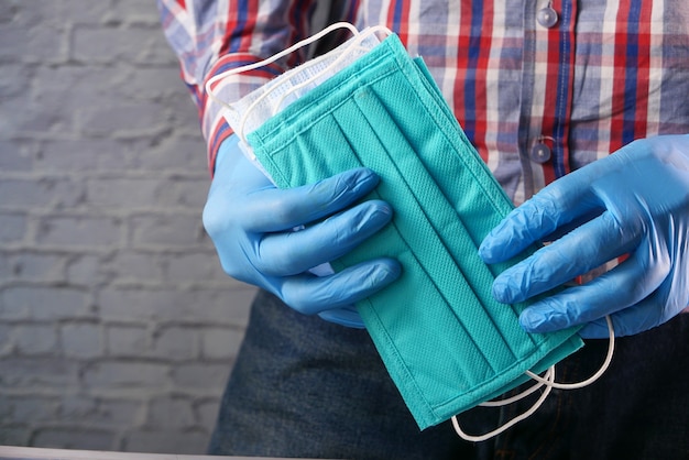 Man hand holding surgical face mask, close up