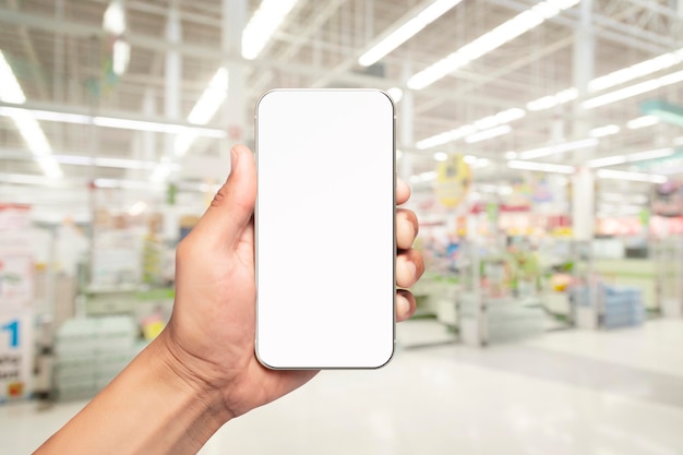 Man hand holding and using at touch screen smartphone over\
blurred background in supermarket shopping by smartphone\
concept