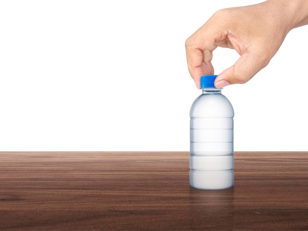 A man hand holding a water bottle on a wooden table