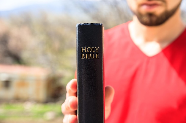 男は自然の中で聖書を手します。