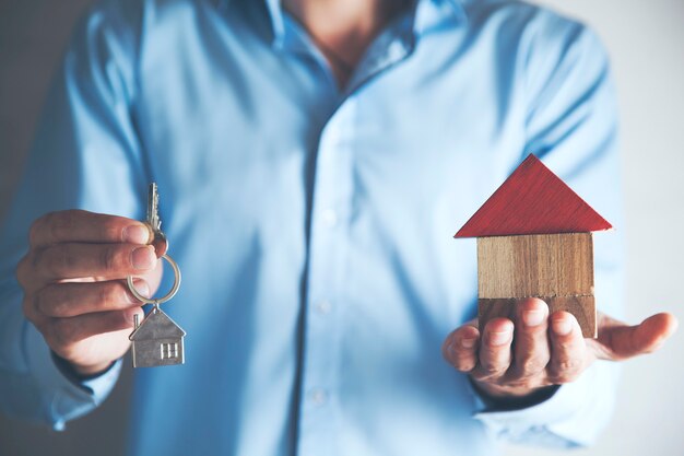 Man hand house model with key