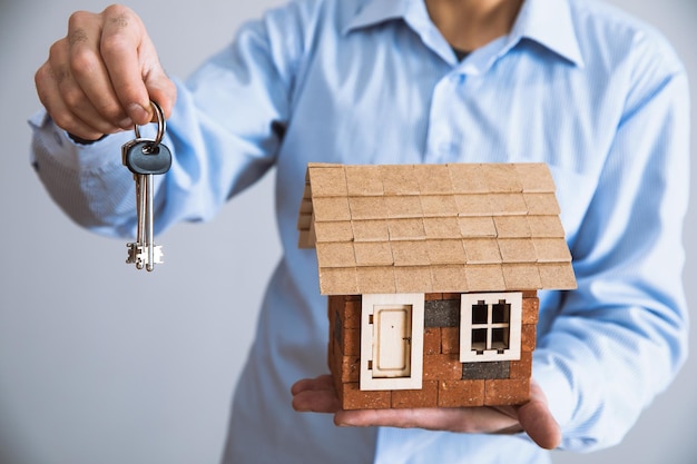 Man hand house model with key