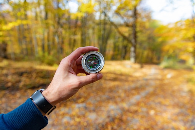 Man hand kompas met herfst bos