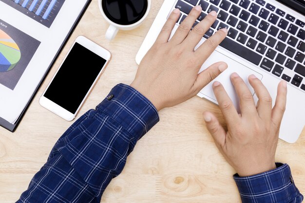 Man hand on laptop keyboard with blank screen monitor, man working business working on wood