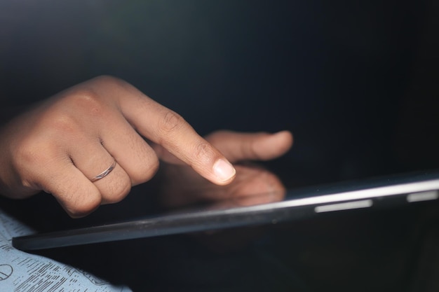 man hand met behulp van digitale tablet op zwarte achtergrond