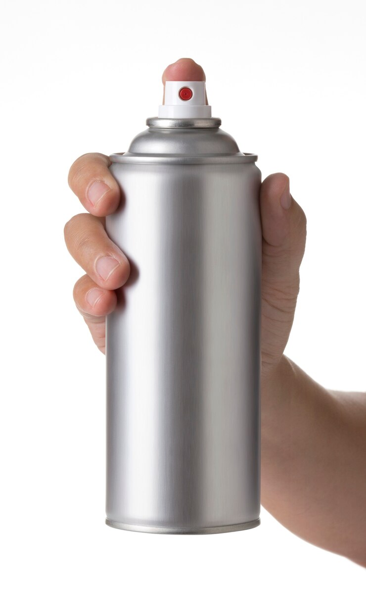 Foto man hand met een lege aluminium verfspuit fles