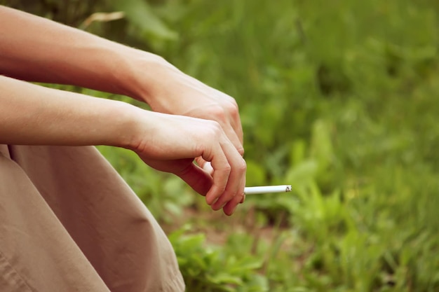 Man hand met een sigaret op natuur achtergrond