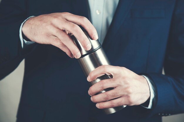 Man hand met metalen thermos