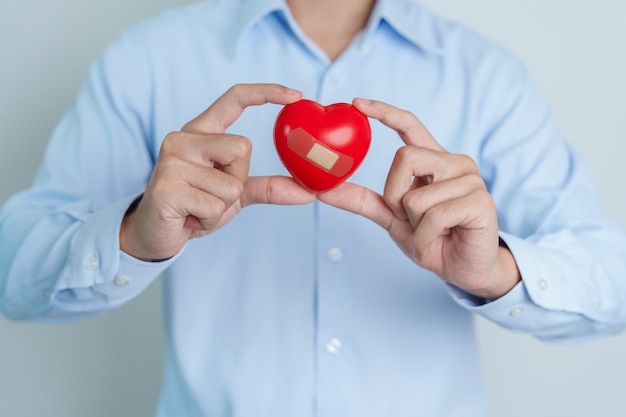 Man hand met rood hart vorm liefde donor wereldhart dag wereldgezondheidsdag en verzekeringsconcepten