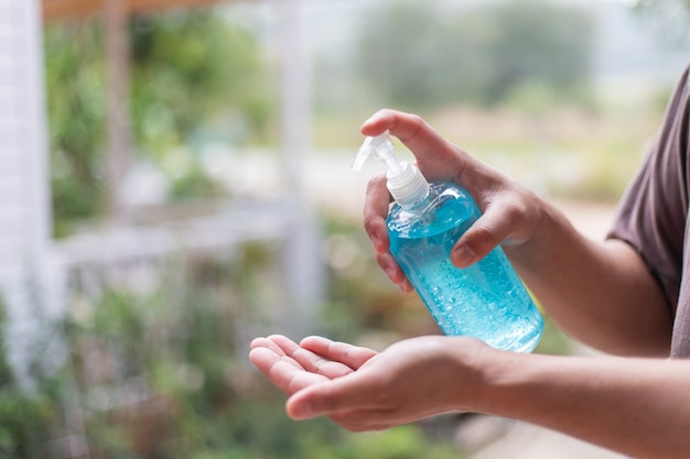 Foto man hand met was handdesinfecterend gel dispenser, tegen nieuw coronavirus of corona virusziekte (covid-19) op openbare indoor