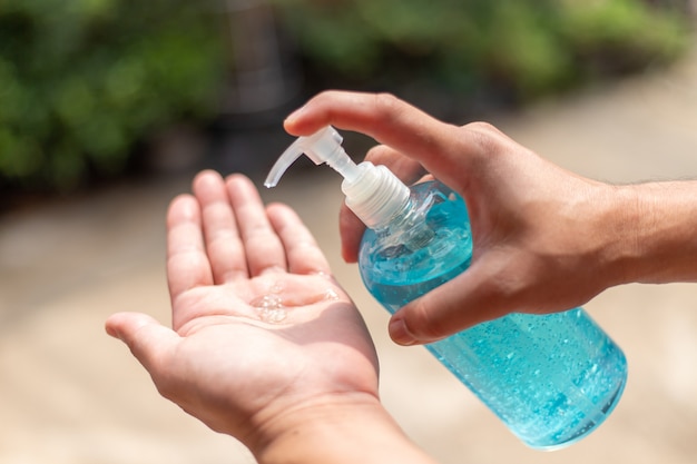 Foto man hand met was handdesinfecterend gel dispenser, tegen nieuw coronavirus of corona virusziekte (covid-19) op openbare indoor