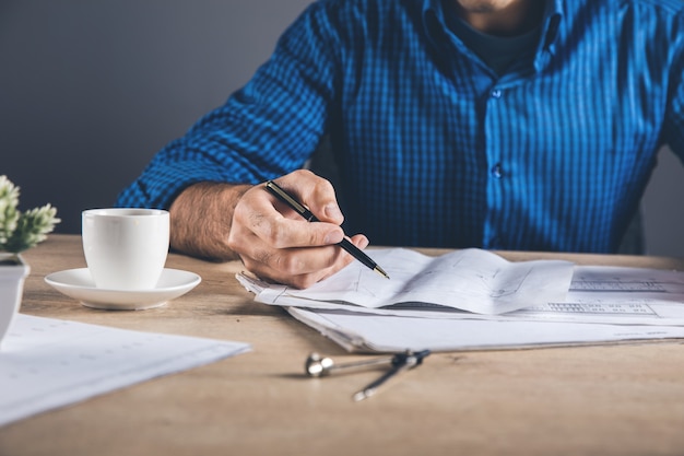 Man hand pen with drawings on desk