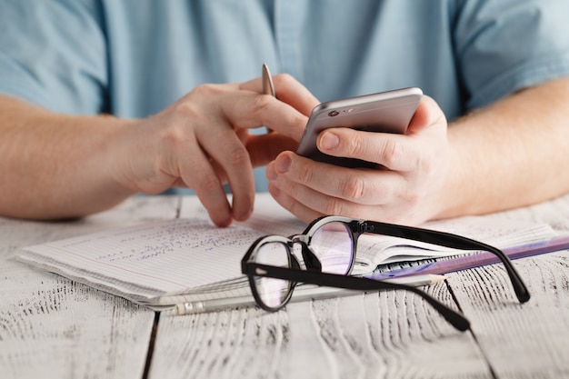 Man hand phone and calculator in office table