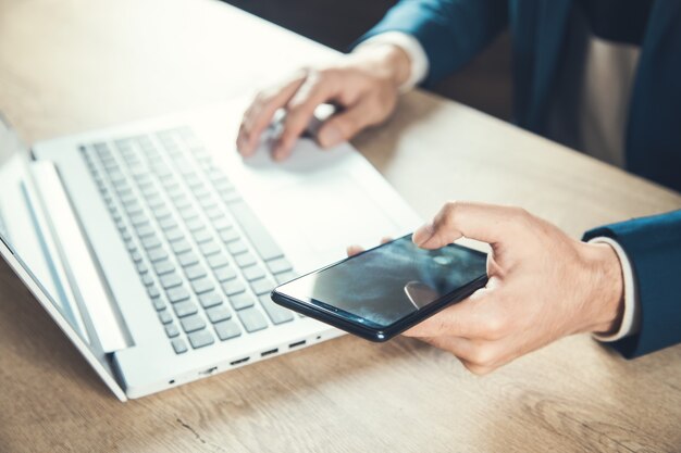 オフィスデスクの男の携帯電話