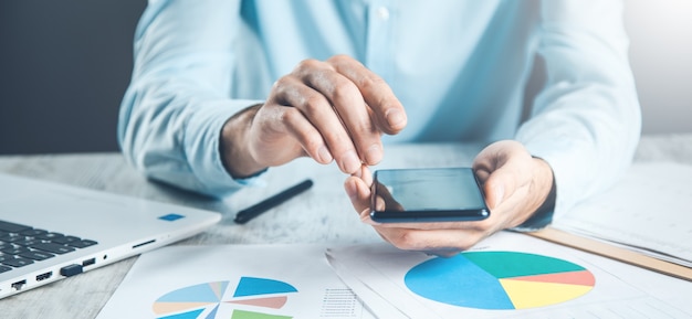 Man hand phone with document on desk