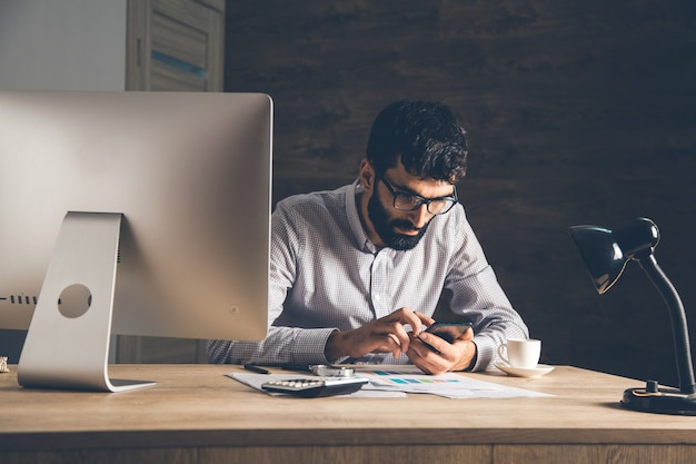 Man hand phone with office desk