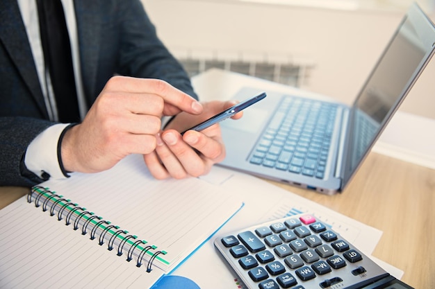 Man hand phone in working desk