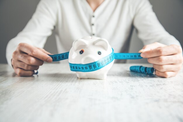 Man hand piggy bank with meters on desk