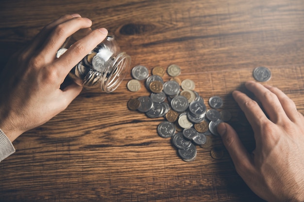 Man hand pot met munten op bureau