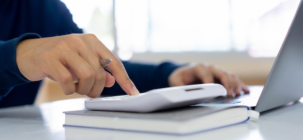 Man hand pressing on calculator for calculating cost estimate