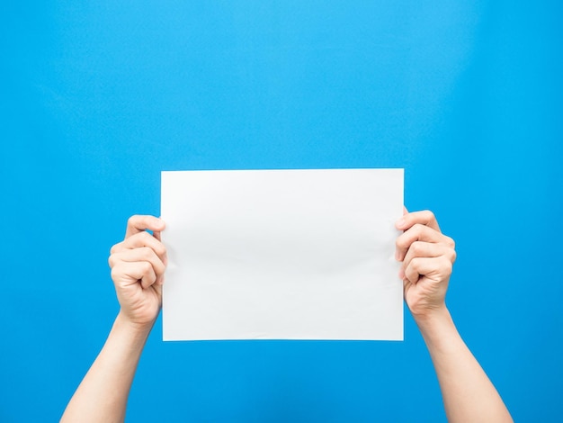 Man hand show white paper empty blue background