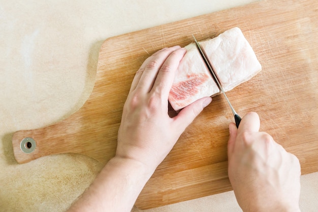 man hand snijdt de stukjes vet