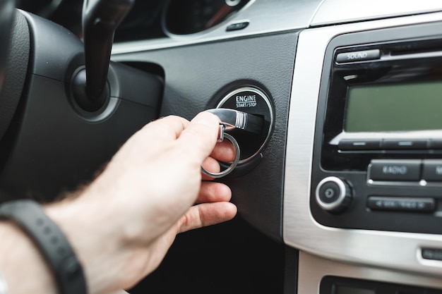 Man hand steek de sleutel in het contactslot van de auto contactsleutel van de auto